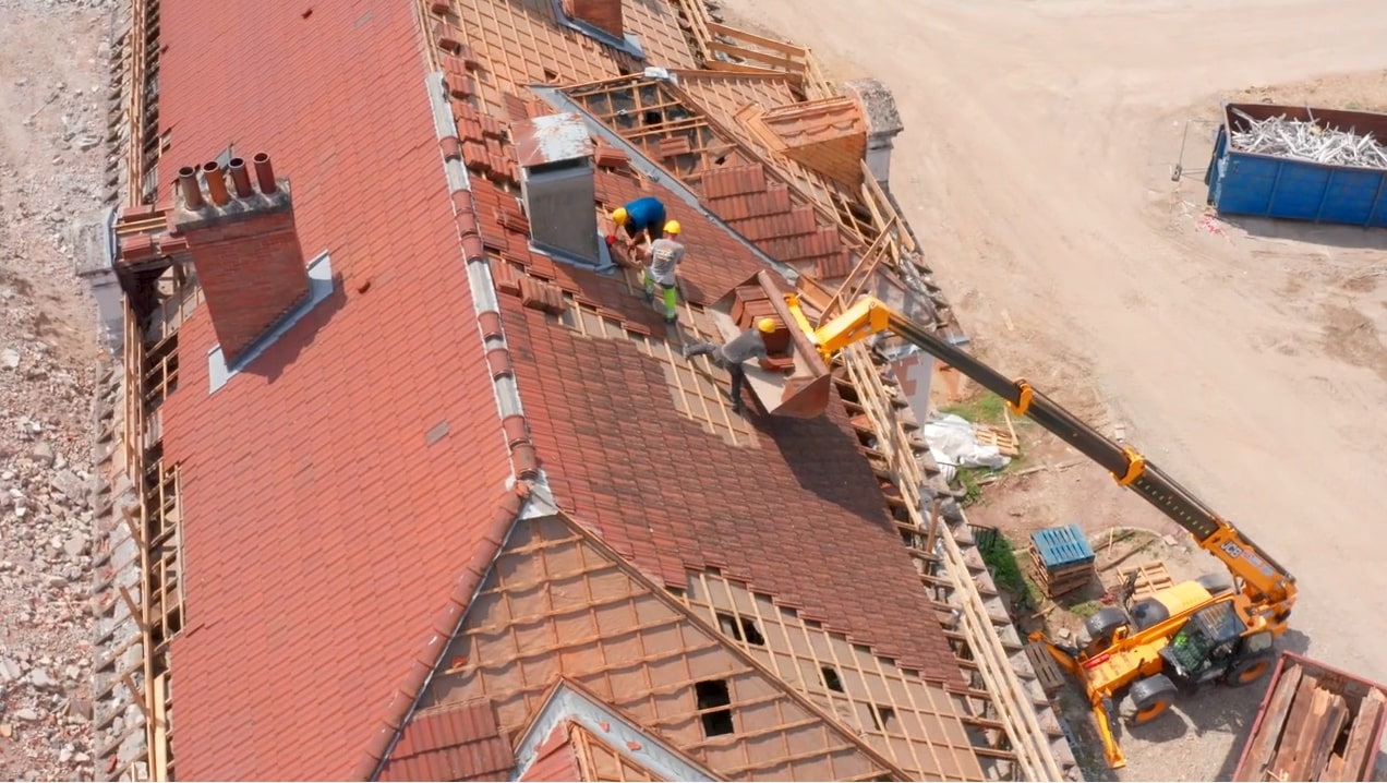 A view from above of workers deconstructing a roof.