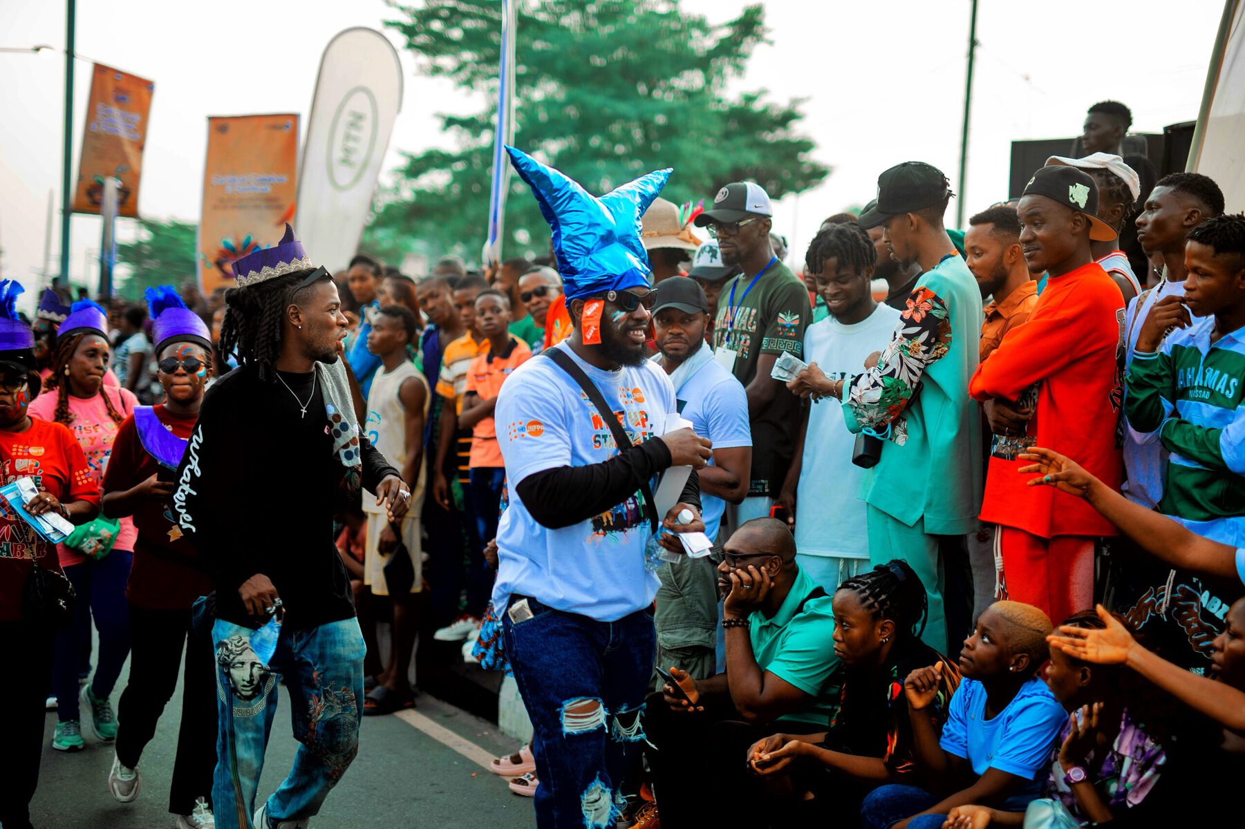 A volunteer from the Wise Up Calabar campaign speaks with spectators at the Carnival.