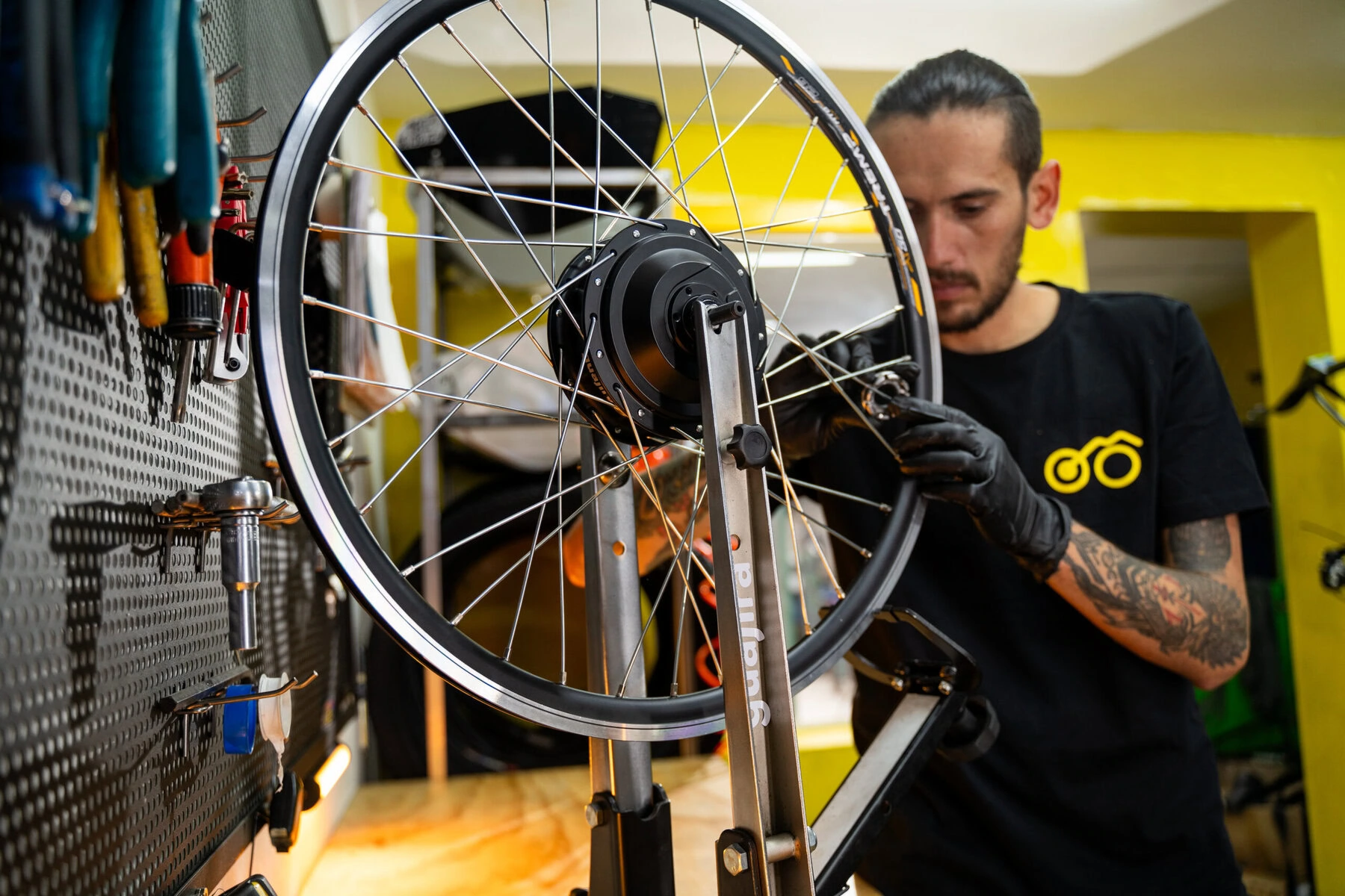 A Guajira employee works on a bike wheel.