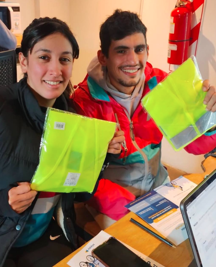 Workers at a Nippy center hold up neon yellow packets wrapped in plastic.